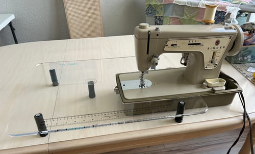 Reviewer's clear Sew Steady Extension Table fitted perfectly around a vintage Singer sewing machine on a wood table.