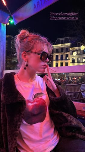 Reviewer styles the white rotten baby tee with a furry jacket and sunglasses for a night out.