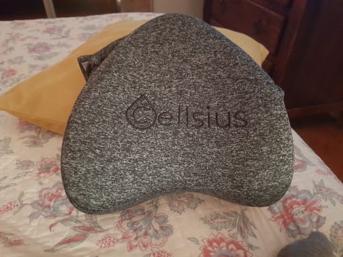 Avis d'une cliente montrant son coussin genoux Cellsius avec la housse grise chinée sur un lit.
