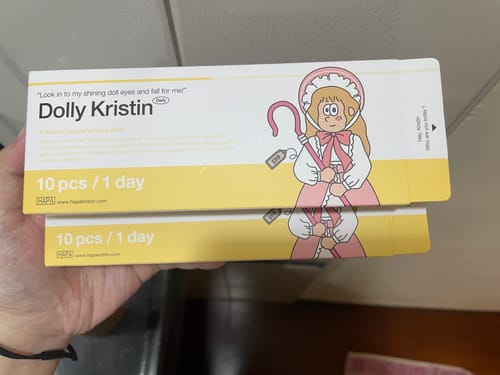 顧客手拿著兩盒 Dolly Kristin 1Day 隱形眼鏡的產品包裝。