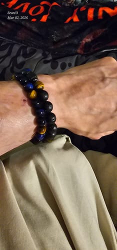 A close-up of a reviewer's wrist wearing the beaded Nighthawk Tiger's Eye Bracelet.