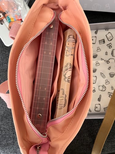 Close-up of a reviewer's open Bees & Blossoms Journal Buddy, showing a sticker binder and journal inside.