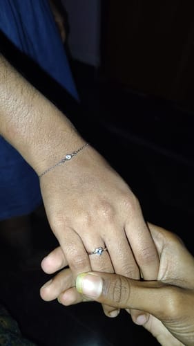 Close-up of a customer's hand wearing the heart-shaped Silver Passionate Love Ring, held by another person.
