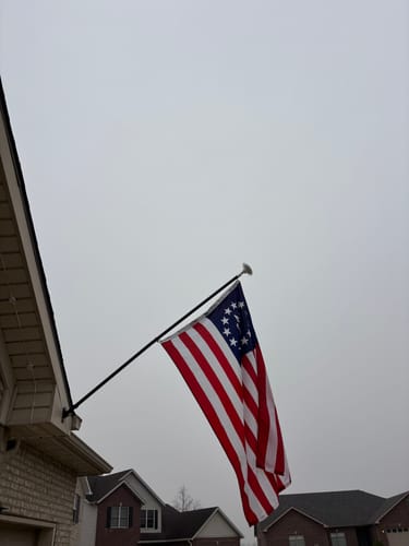 Customer's America 250™ Betsy Ross Flag flying from a flagpole on a cloudy day.