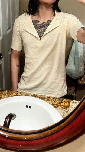 Close-up of a reviewer wearing the cream 1890s Slub Cotton Henley T-Shirt, showing its slim fit with the top unbuttoned.