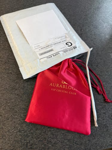 Packaging for the customer's VIP Crystal Club order, showing the mailer and red satin pouch.