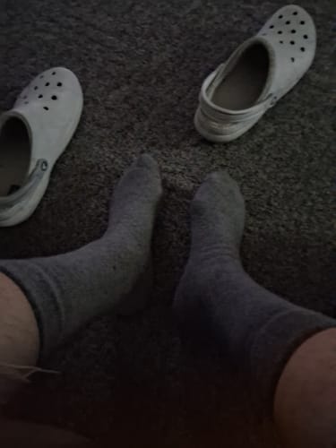 Customer's first-person view of their feet wearing the grey FTR Men's Alpaca Socks on a carpet.