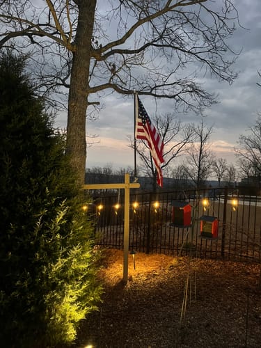 Reviewer's Prestige House Flag Pole mounted on a yard post, with the flag hanging down at dusk.