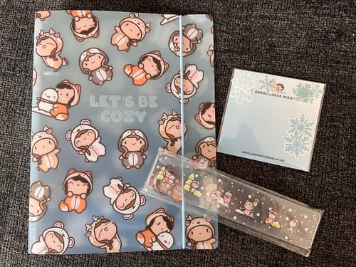 Customer's Winter Onesie Town freebie set, showing the binder, ruler, and washi flakes on a dark surface.