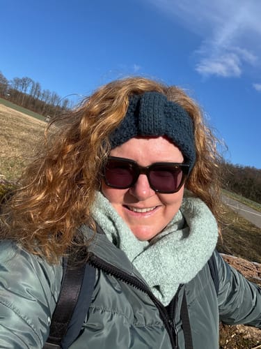 Kundin mit glänzendem, lockigem Haar nach der Anwendung der Apple-Wonder Haarseife im Freien.