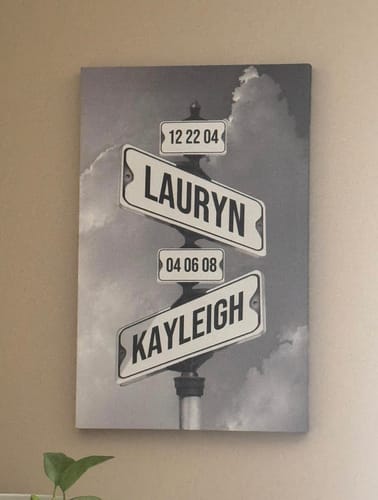 Customer's personalized canvas showing a black-and-white street sign design with the names Lauryn and Kayleigh and birth dates.