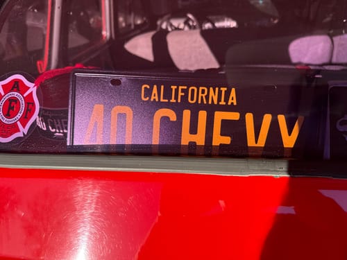 Customer's custom California metal license plate reading '40 CHEVY' displayed inside a car's rear window.