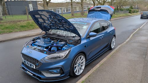 Reviewer's blue car with the hood open, showing the clean engine bay after using the Citrus Wash.