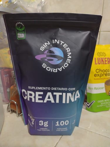 Reseñador muestra el empaque negro de su Creatina Monohidrato en una encimera.