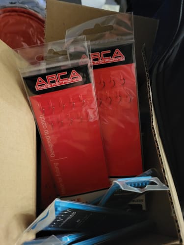 Klant toont de verpakkingen van de POLE SPECIAL BARBLESS RIG in een doos.