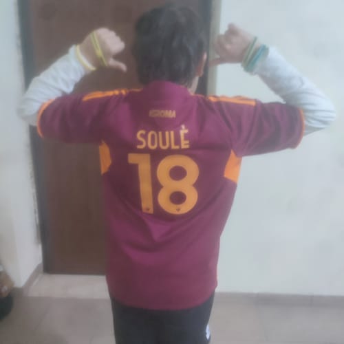 Vista posteriore di un cliente che indossa una maglia personalizzata bordeaux con il nome "Soulè" e il numero 18.