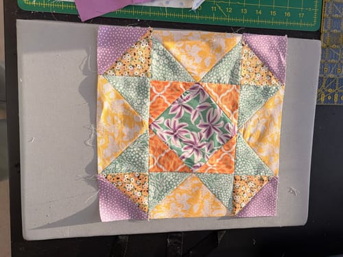 Customer's colorful mosaic quilt block from the Mrs Quilty Subscription Box, showing an intricate star pattern.