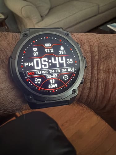 Customer's smartwatch on their wrist, showing a detailed digital face with time, date, and health stats.