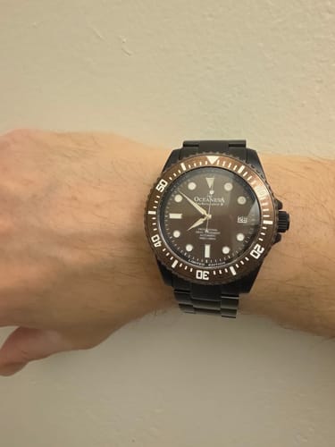 Customer's Oceaneva Deep Marine Explorer III watch, showing the aged bronze dial and black band on their wrist.