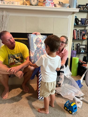 Customer's child receiving a personalized fireman portrait from two adults in a living room.