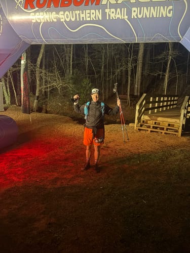 Reviewer celebrating at the finish line of a night trail race after using SuperCharged Honey.