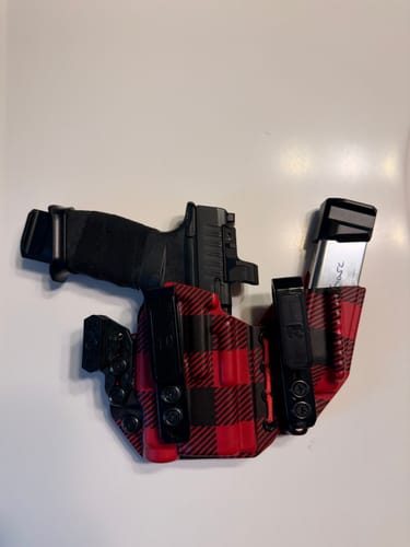 Customer's red and black plaid AXIS ELITE holster with a firearm and magazine secured inside on a white surface.