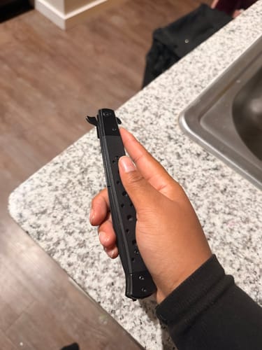 Customer holding the black 12" Big Boy Stiletto knife closed in their hand.