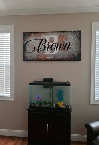 Customer's rustic Family Last Name Sign, personalized with 'Brown' and 'EST. 2011', hanging on a wall above an aquarium.