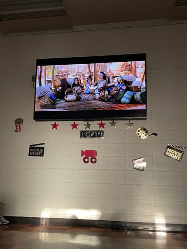 Customer's church movie night, with the film DAVID playing on a large TV above festive, themed decorations.