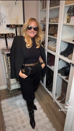 Reviewer wearing the black Sculpt Seamless Sleeveless Ribbed Top styled under a blazer in a closet.