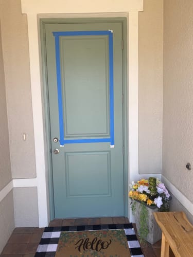 Reviewer's front door with the top panel marked with blue tape in preparation for a window installation.