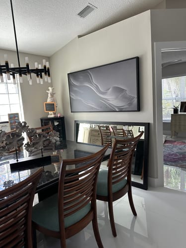 Customer's Black Minimalist Wall Art hanging horizontally in a dining room above a mirror.