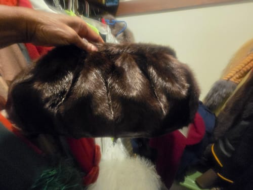 Customer holding the plush, dark brown Faux Mink Handbag in a closet.