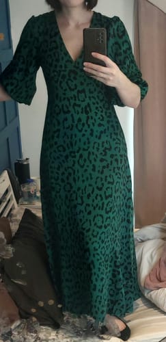 Reviewer shows the flattering fit of the Green Animal Print Satin Midi Dress in a mirror.