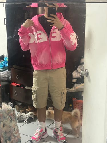 Reviewer showing the fit of their distressed pink SEEK ZIPUP hoodie in a mirror selfie.