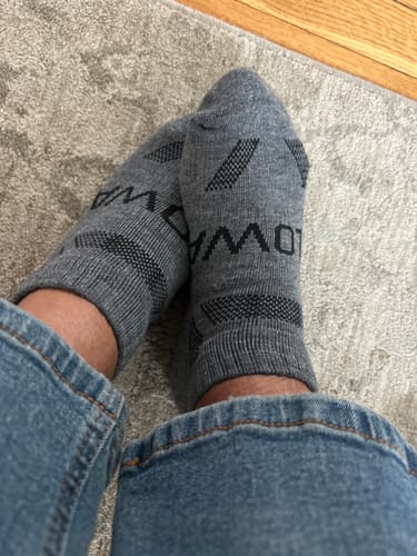 Customer wearing a pair of grey Men's Alpaca Socks, showing the ankle length.