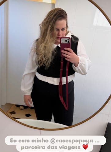 Cliente tirando uma selfie no espelho para mostrar sua Case Bordô com alça.
