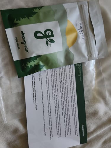 Customer's white and green pouch of Blue Dream product lying next to an informational card.