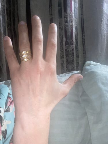 Cliente mostrando el Anillo Ajustable Albo dorado en su mano, destacando las tres bandas y las piedras.
