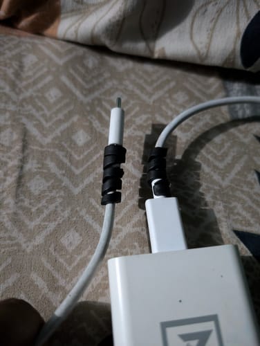 Customer's two black cable protectors wrapped around the ends of white charging cables to prevent fraying.
