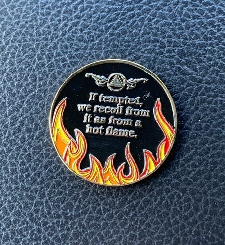 Customer's close-up of the back of the black Sobriety Mint medallion showing the colorful 'hot flame' design and promise text.