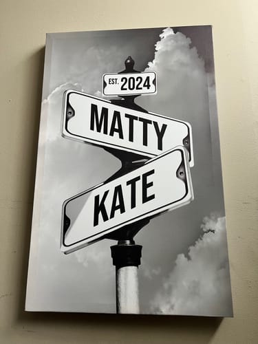 Customer's personalized street sign canvas shown up close, featuring the names 'MATTY' and 'KATE' and 'EST. 2024'.