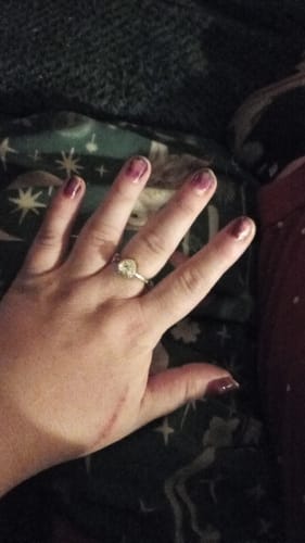A reviewer's hand wearing the Forever In My Heart Urn Ring, which has a silver band and a round centerpiece.