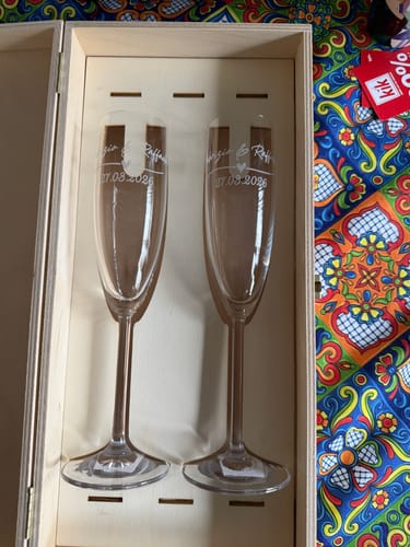 Kunde zeigt die personalisierten Leonardo Sektgläser in ihrer offenen Geschenkbox aus Holz.