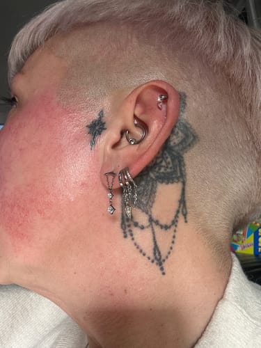 Customer wearing the Hera Hidden helix Silver earring in their lobe, styled with several other silver piercings.