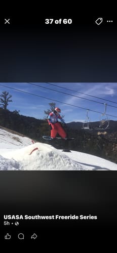 Reviewer wearing red Super Baggy Snow Bibs while going off a jump on a snowy mountain.