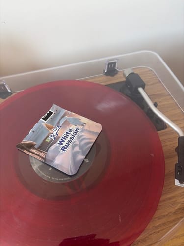 Customer's packet of Rollz White Russian flower displayed on a red vinyl record.