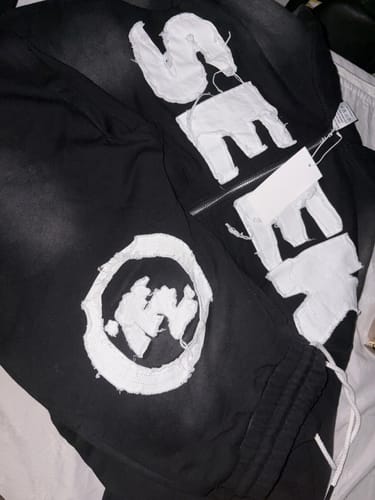 Customer's black SEEK VISIONZ SET laid out, showing the frayed white appliqué lettering and logos.