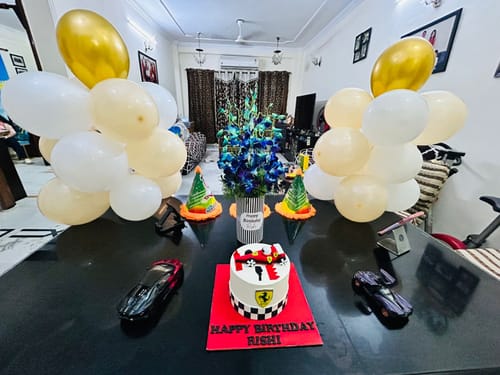 Customer's Ferrari Racing Cream Cake on a decorated table for a birthday party with balloons and toy cars.