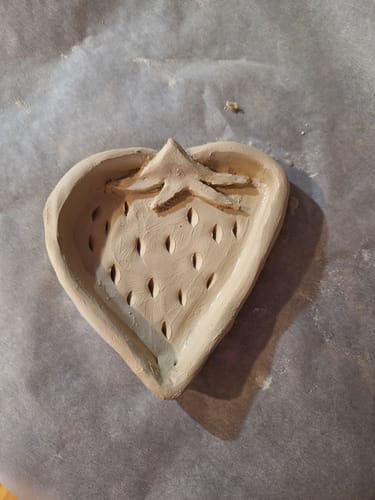 Customer's unpainted clay strawberry dish, a trinket made from the craft subscription box.